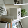KEF Q1 META enceinte bibliothèque blanc, mise en situation sur étagère de salon avec livres et plantes