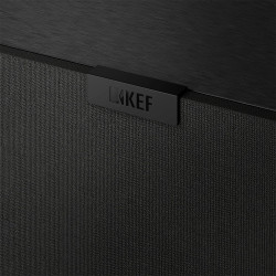 KEF Q4 META enceinte surround, détail logo KEF sur grille tissu noir et finition coffret