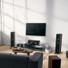 DYNAUDIO EMIT 30 colonnes noyer intégrées dans salon avec écran TV et caisson de basses