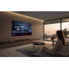 SAMSUNG TQ83S92H TV OLED 83 pouces dans salon contemporain, interface IA affichée et utilisatrice avec télécommande