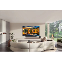 LG OLED83G6 TV OLED 83 pouces fixée au mur, salon avec canapé arrondi et barre de son